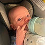 baby, infant, bottle, feeding, car_seat, blanket, blue_clothing, hand, face, eyes, newborn, child, indoors, closeup, cute, comfort, resting, star_pattern, soft, person