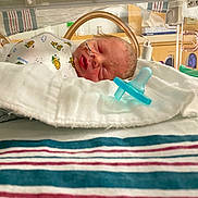 Matthew is registered to the contest to win money with this photo: newborn, baby, hospital, incubator, pacifier, blanket, sleeping, infant, medical, nursery, cute, onesie, face, head, striped, resting, healthcare, tiny, patient, peaceful