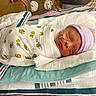 newborn, baby, hospital, incubator, blanket, swaddled, sleeping, hat, oxygen_tube, medical, infant, cute, striped_hat, peaceful, face, child, bed, healthcare, person, resting
