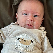 Gabriel a rejoint le concours — aidez-le/la à gagner de superbes lots ! baby, casual, closeup, clothing, cute, embroidered_sheep, eyes, fabric, face, head, indoors, infant, person, portrait, sitting, skin, sleeve, soft_lighting, text, young_child