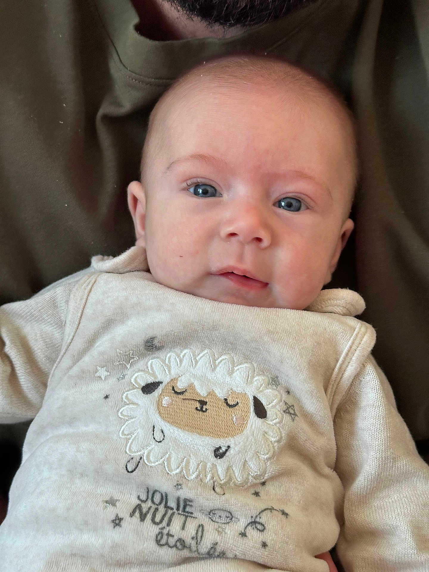 Gabriel a rejoint le concours — aidez-le/la à gagner de superbes lots ! baby, casual, closeup, clothing, cute, embroidered_sheep, eyes, fabric, face, head, indoors, infant, person, portrait, sitting, skin, sleeve, soft_lighting, text, young_child