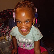 Ah'Lannah joined the competition — help win amazing prizes! braids, candid_photo, casual_clothing, chair, child, colorful_clips, dark_skin, flash_photography, furniture, girl, green_shirt, hair_accessories, happy, home, indoors, pink_shorts, portrait, sitting, smiling, teeth