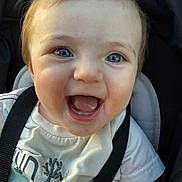 Matteo is registered to the contest to win money with this photo: baby, child, smile, happy, blue_eyes, car_seat, seatbelt, white_shirt, closeup, face, infant, cute, joyful, young_child, person, portrait, sitting, clothing, straps, daylight