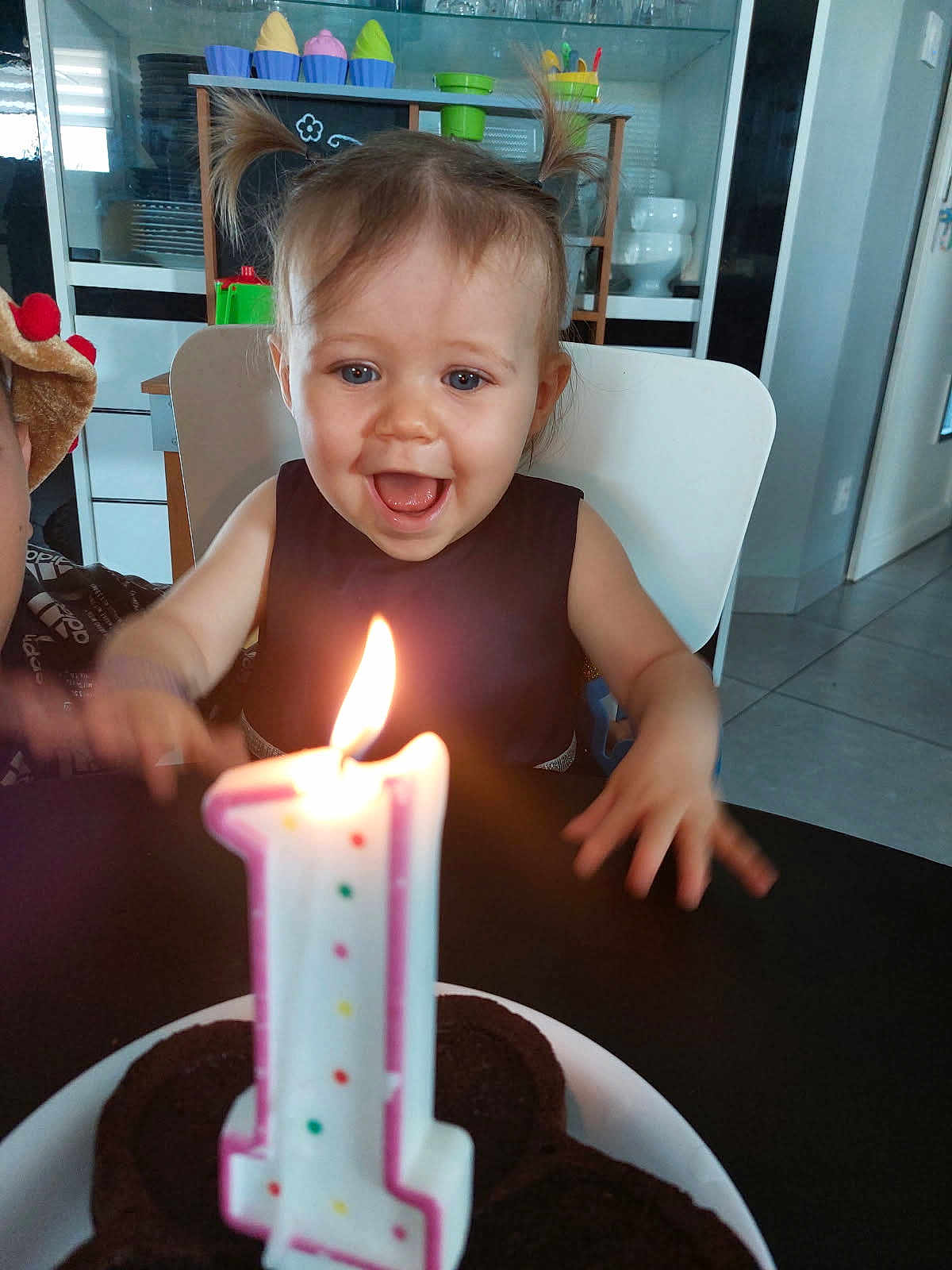 Melodie participe au concours pour gagner de l'argent avec cette photo : toddler, child, birthday, candle, cake, celebration, happy, excited, pigtails, face, mouth_open, table, plate, chocolate_cake, indoor, kitchen, chair, person, smile, lighting