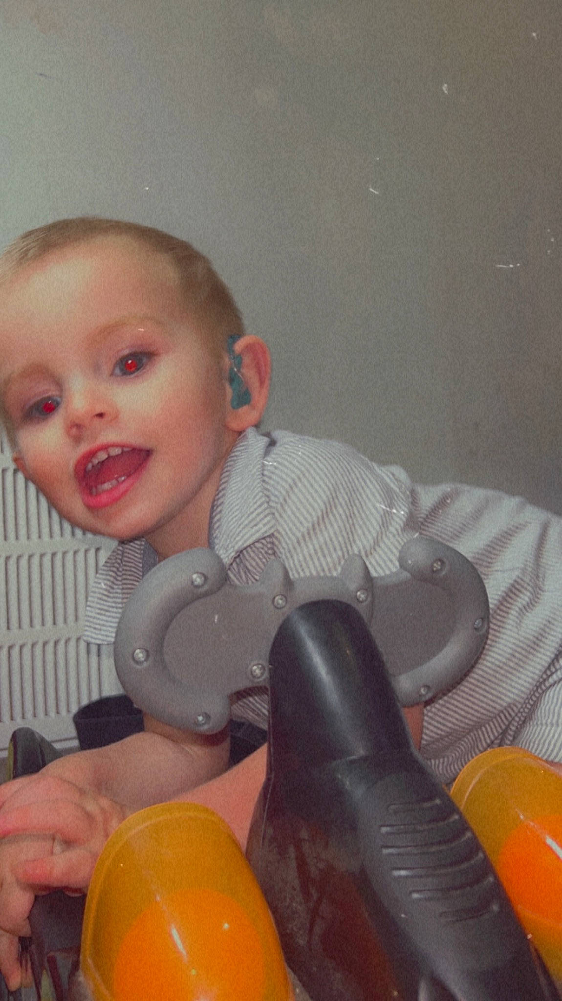 Jensen is registered to the contest to win money with this photo: baby, balloon, child, comfort, fun, happy, human_leg, knee, lap, leg, mouth, orange, person, personal_protective_equipment, room, sitting, studio_couch, thigh, tie, toddler