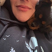 Billie Eilish joined the competition — help win amazing prizes! black_hoodie, closeup, cozy, cuddling, dog, eyes, face, fur, graphic_print, hoodie, indoor, lip_ring, nose, person, pet, portrait, puppy, relaxed, smile, woman