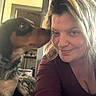 Stella participe au concours pour gagner de l'argent avec cette photo : woman, dog, pet, selfie, portrait, smiling, kissing, affection, companion, indoors, home, kitchen, furniture, long_hair, brown_dog, fluffy, black_and_tan, casual, warm_lighting, candid