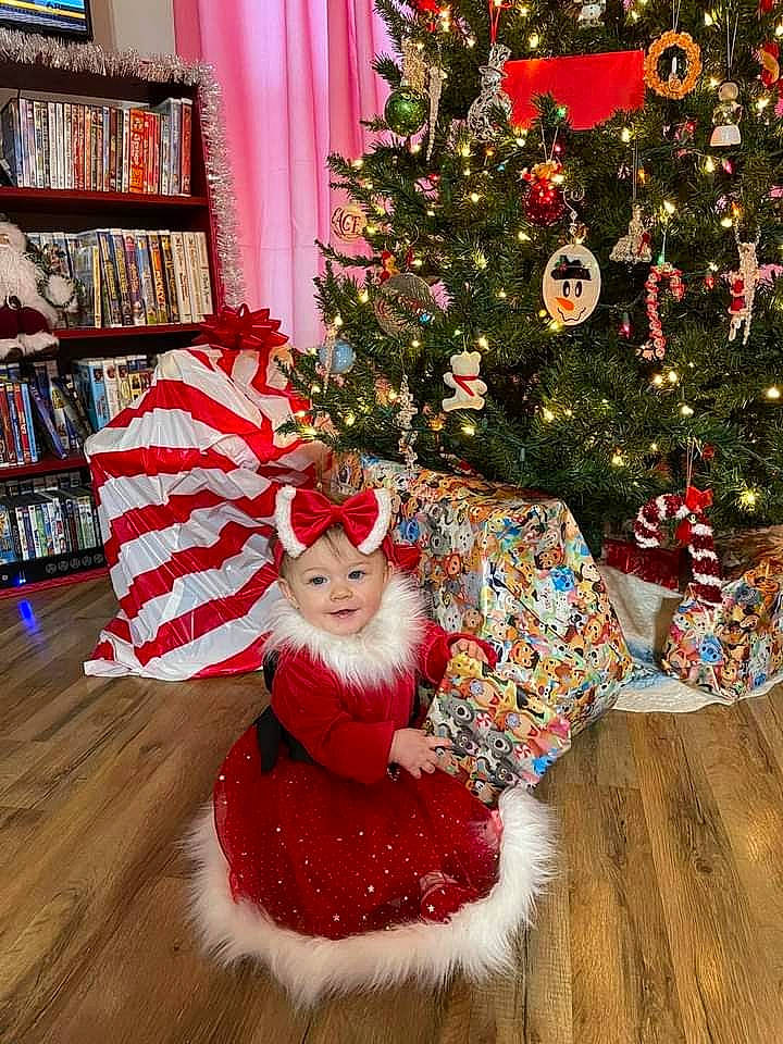 Serenity is registered to the contest to win money with this photo: bookcase, christmas, christmas_decoration, christmas_eve, christmas_ornament, christmas_tree, costume_hat, event, evergreen, hat, headwear, holiday, holiday_ornament, ornament, person, plant, red, shelf, shelving, tradition