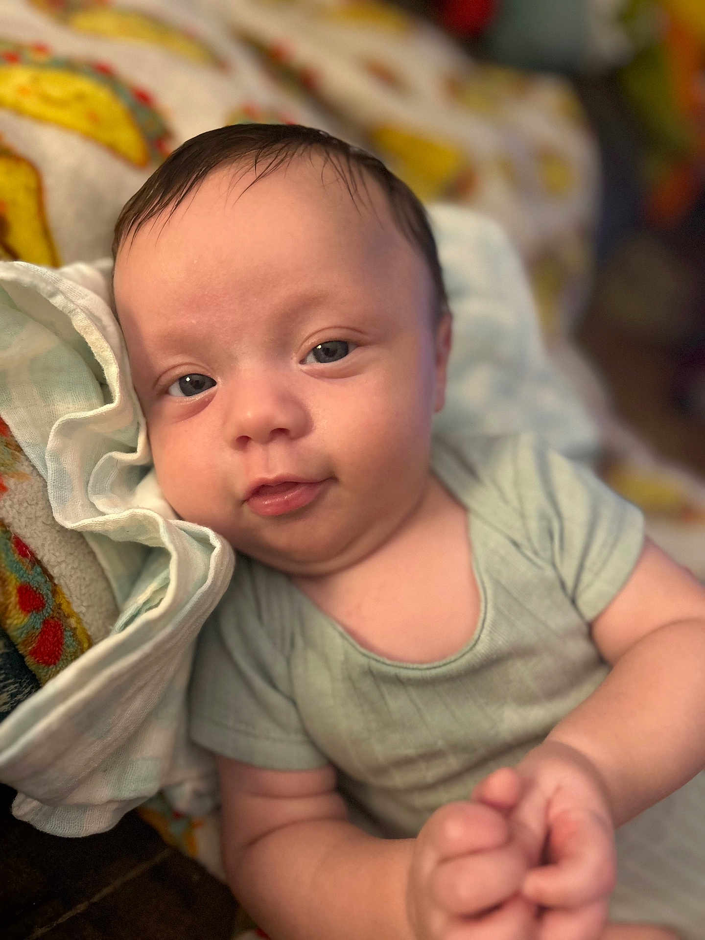 Timothy joined the competition — help win amazing prizes! baby, infant, child, face, skin, hand, clothing, blanket, fabric, portrait, cute, lying_down, soft_texture, closeup, newborn, smile, blue_eyes, indoors, comfort, resting