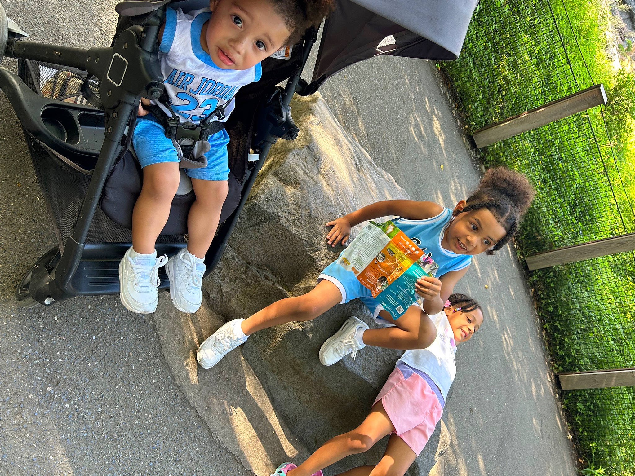 Cassian is registered to the contest to win money with this photo: asphalt, baby, chair, child, flip_flops, fun, grass, happy, human_leg, leisure, person, recreation, sandal, shoe, shorts, sitting, sneakers, t_shirt, thigh, toddler