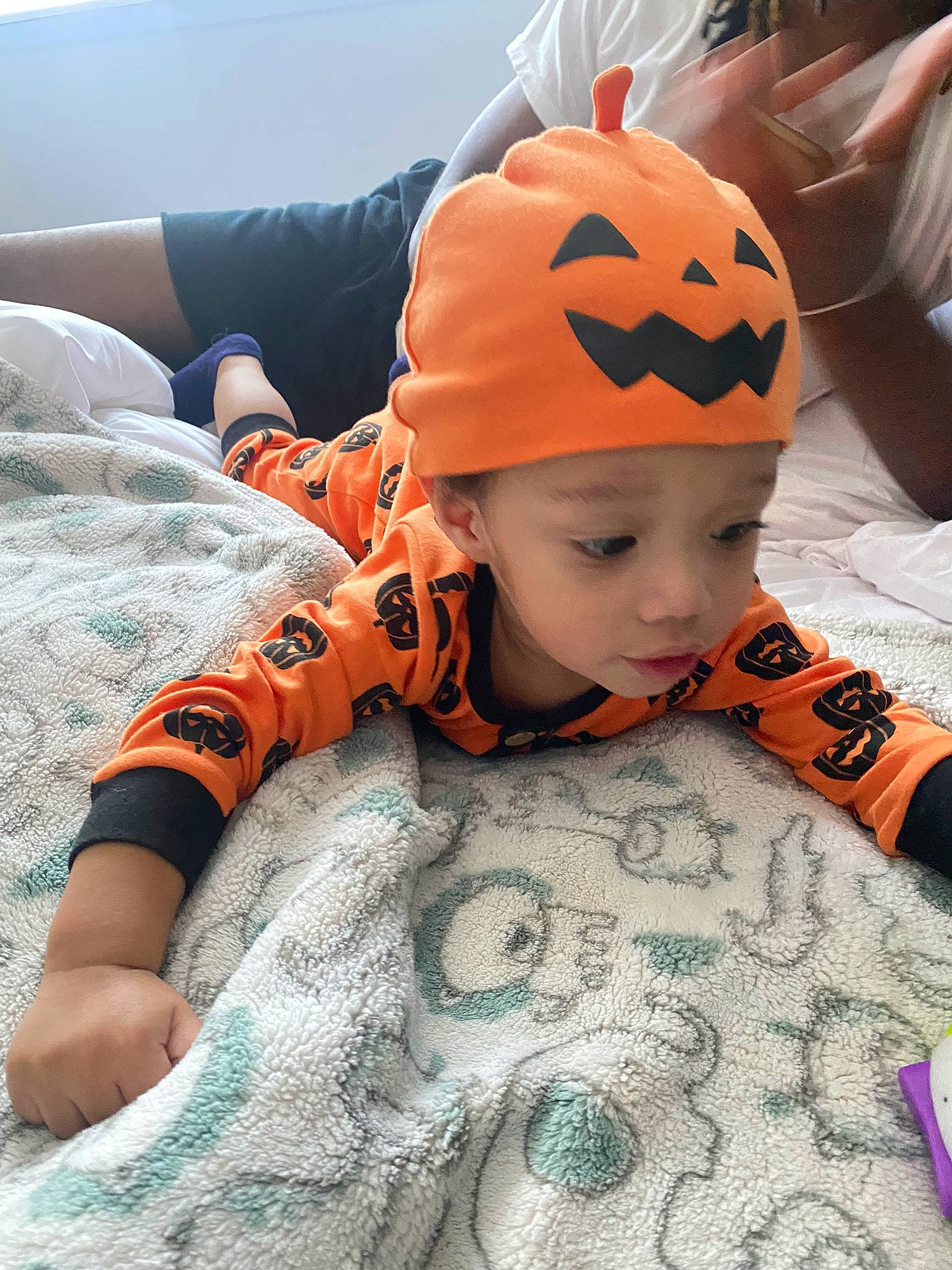 Cassian is registered to the contest to win money with this photo: baby, baby_toddler_clothing, beanie, bicycle_helmet, cap, child, comfort, fashion_accessory, flooring, fun, happy, headwear, knit_cap, linens, orange, pattern, person, personal_protective_equipment, pumpkin, sleeve