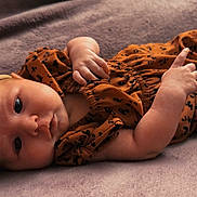 Davina joined the competition — help win amazing prizes! baby, infant, headband, bow, clothing, laying_down, blanket, cute, young_child, portrait, skin, face, hand, foot, indoors, soft_texture, sleepwear, expression, newborn, child