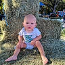 baby, child, hay, outdoor, nature, grass, seat, throne, person, trees, sunlight, people, summer, casual, barefoot, expression, sitting, daytime, blue_sky, event