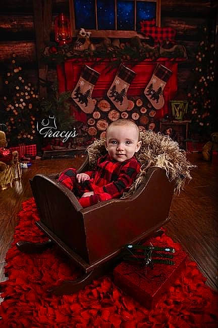Dustin is registered to the contest to win money with this photo: baby, carmine, carpet, chair, christmas, christmas_decoration, comfort, event, floor, flooring, holiday, joy, magenta, person, rectangle, red, room, sitting, smile, toddler