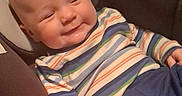 Austin is registered to the contest to win money with this photo: baby, blue_pants, car_seat, casual, child, clothing, comfort, cute, face, hand, happy, head, indoor, infant, person, portrait, seat, smiling, striped_shirt, young_child