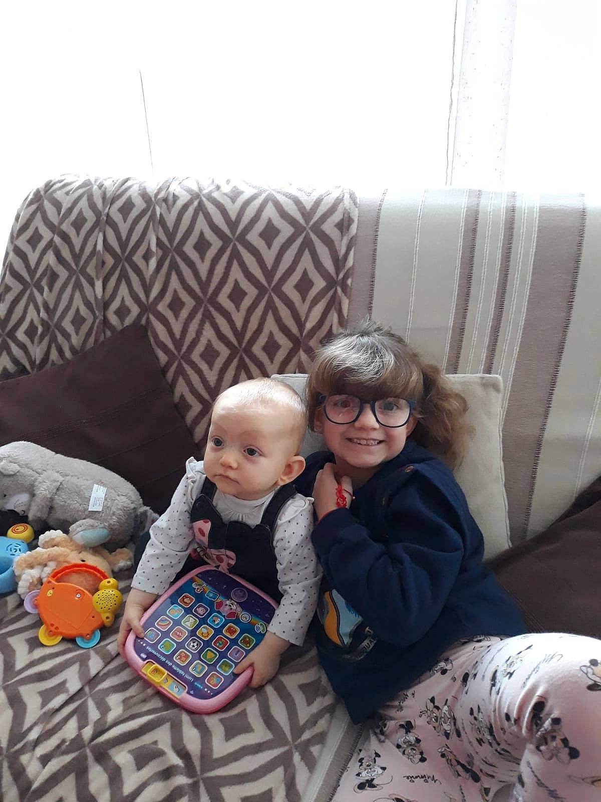 Rosalie participe au concours pour gagner de l'argent avec cette photo : baby, child, comfort, couch, floor, flooring, fun, glasses, joy, lap, living_room, person, play, room, sitting, smile, sofa_bed, textile, throw_pillow, toddler