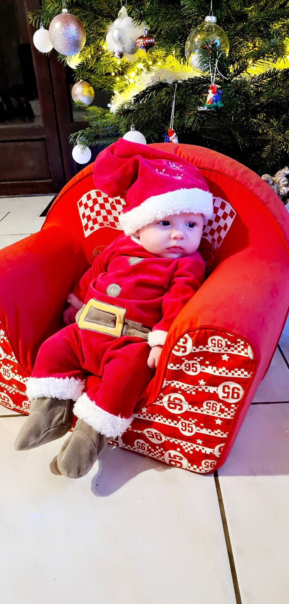 Tylia participe au concours pour gagner de l'argent avec cette photo : baby, baby_toddler_clothing, carmine, child, christmas, christmas_decoration, costume_hat, event, fictional_character, fun, hat, headwear, holiday, lap, magenta, ornament, person, pink, red, santa_claus