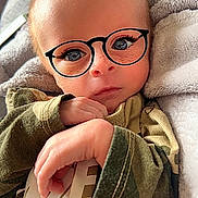 Cooper is registered to the contest to win money with this photo: baby, infant, blanket, glasses_filter, camouflage_clothing, hands, face, eyes, indoor, cute, portrait, young_child, soft_texture, cozy, digital_filter, skin, expression, closeup, person, child