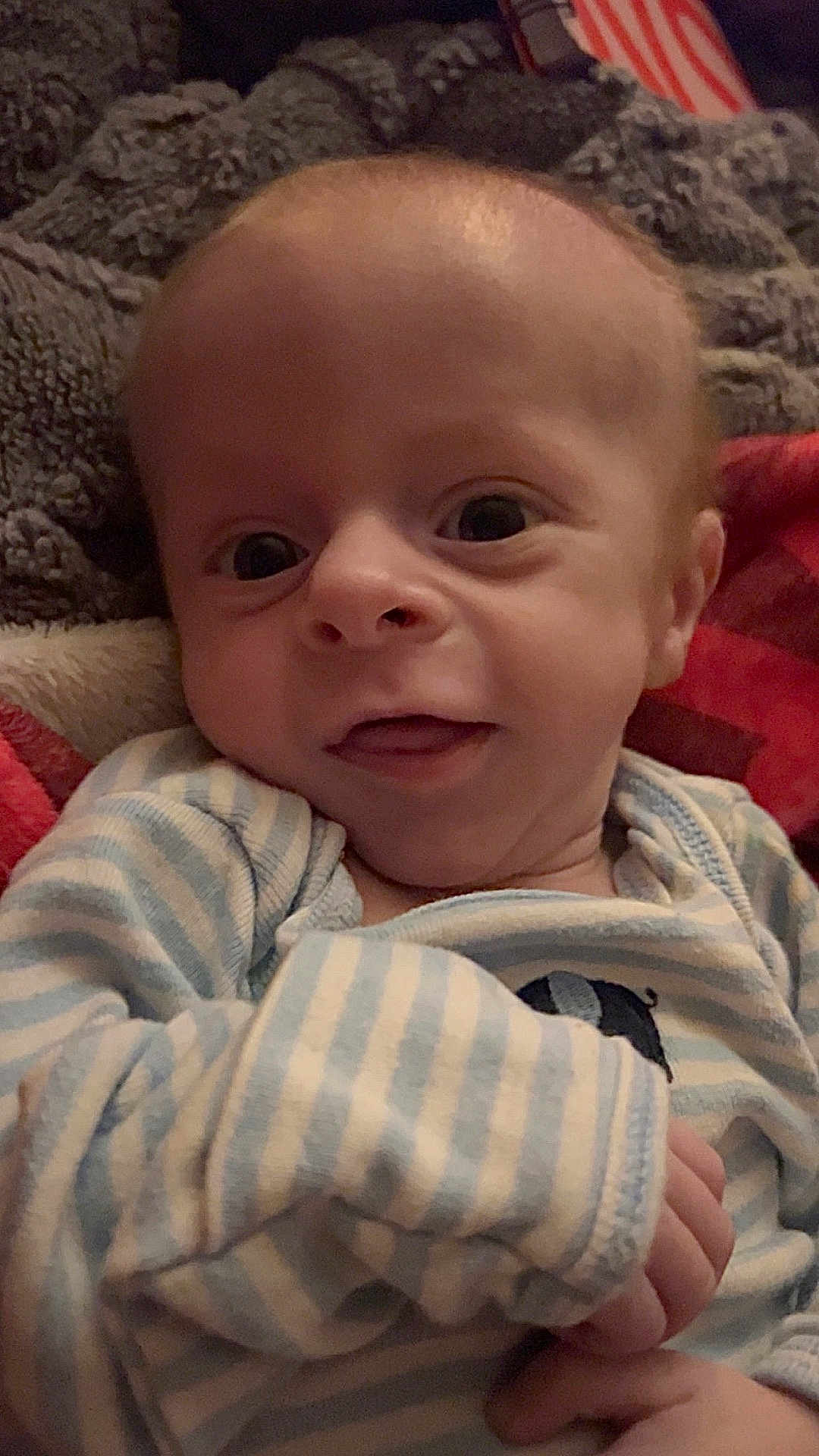 Cooper joined the competition — help win amazing prizes! baby, infant, newborn, child, face, eyes, smile, onesie, striped_clothing, blanket, bedding, cozy, hand, portrait, closeup, indoors, cute, adorable, skin, gaze