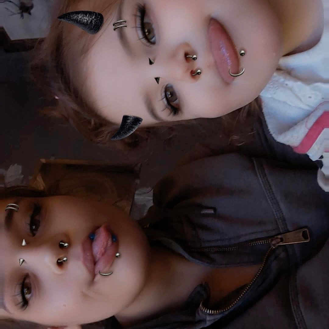 Surenitty joined the competition — help win amazing prizes! brown_hair, casual_clothing, closeup, devil_horn_filter, expression, face_filter, faces, friends, hoodie, indoor, pierced_lip, pierced_nose, piercings, playful, portrait, smiling, tongue_out, two_people, wall_art, young_people