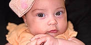Ebony joined the competition — help win amazing prizes! adorable, baby, bow, child, close_up, clothing, curious_eyes, cute, cute_accessory, expression, face, hands, headband, indoor, infant, pastel_colors, person, portrait, soft_skin, young