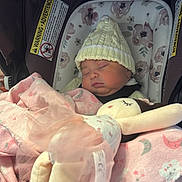 Ebony joined the competition — help win amazing prizes! baby, sleeping, car_seat, blanket, doll, knit_hat, soft_toys, pink, child, infant, cute, cozy, tulle, floral_pattern, wrapped, peaceful, resting, seat_belt, indoors, portrait