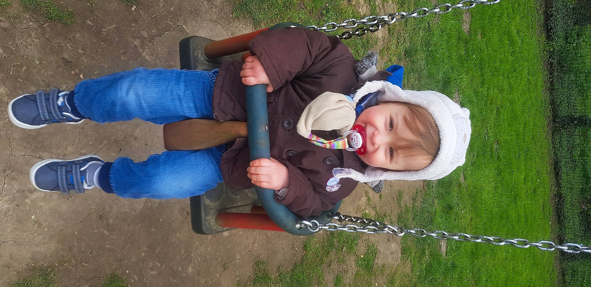 Julyan participe au concours pour gagner de l'argent avec cette photo : baby, baby_toddler_clothing, child, comfort, fun, grass, grassland, happy, hat, leisure, people_in_nature, person, plant, play, recreation, sitting, soil, swing, thigh, toddler