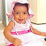 baby, cheerful, child, cute, dress, floor, happy, hat, headwear, indoor, person, pink, playful, polka_dot, sitting, smiling, tile, toddler, white, young_child