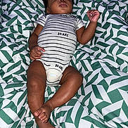 Samir is registered to the contest to win money with this photo: baby, sleeping, onesie, striped_clothing, patterned_blanket, green, white, infant, peaceful, resting, child, cute, soft, comfort, indoors, portrait, skin, foot, hand, young