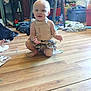 Ember joined the competition — help win amazing prizes! toddler, child, floor, wooden_floor, messy_room, toys, clothes, storage_bins, sitting, smiling, indoor, person, shirt, skirt, baby, furniture, play, home, light, expression