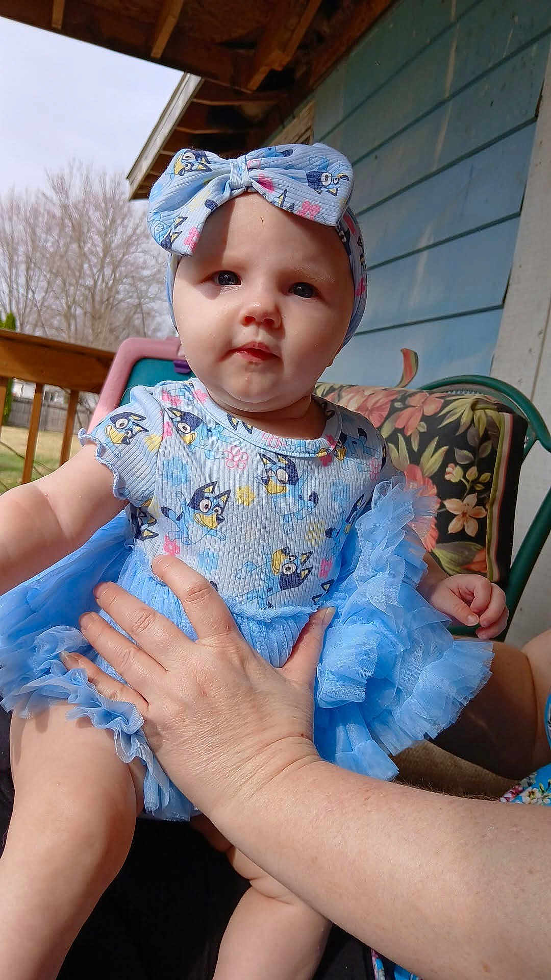 Ember joined the competition — help win amazing prizes! baby, child, tutu, dress, headband, blue, outdoor, porch, hand, person, cute, infant, clothing, floral, chair, railing, summer, smile, face, holding