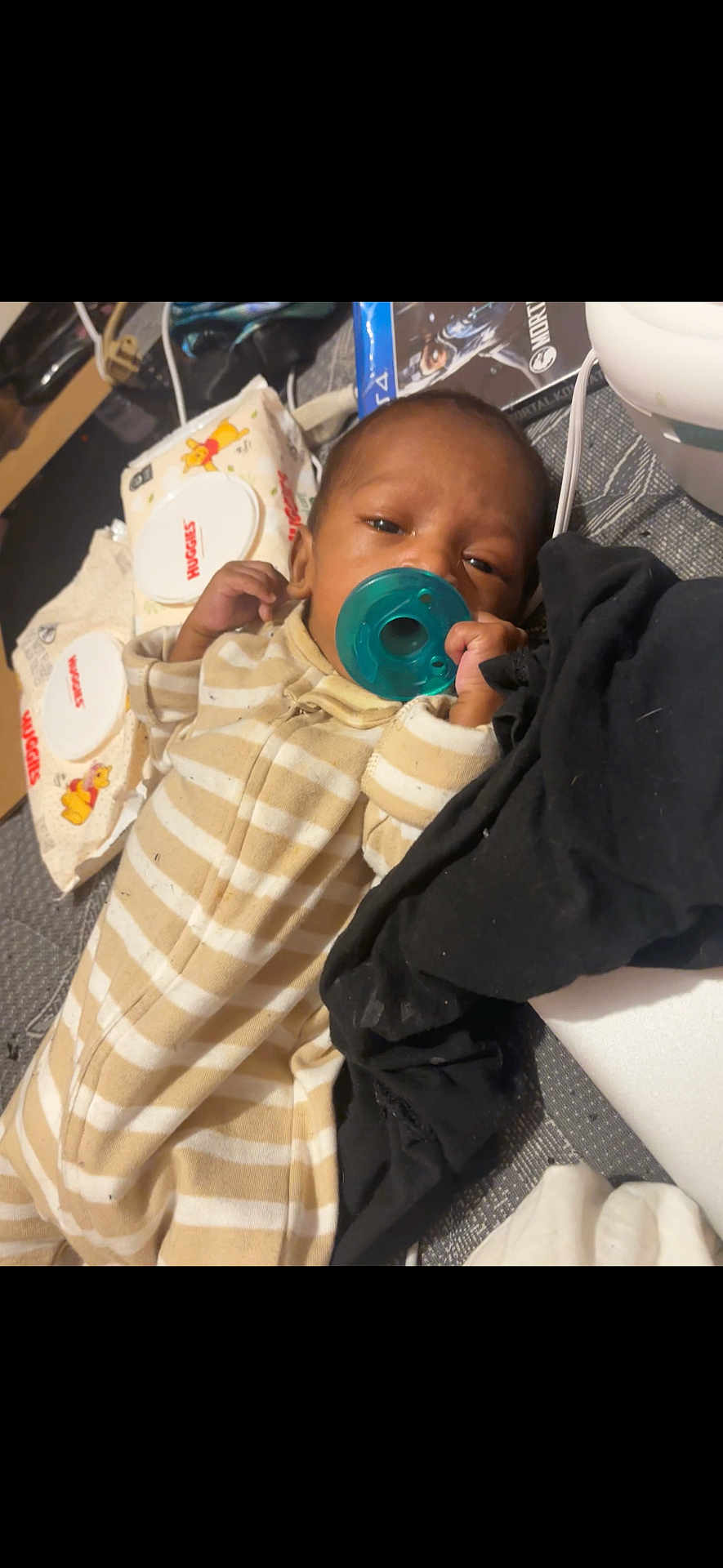 Mada is registered to the contest to win money with this photo: baby, pacifier, striped_onesie, infant, sleepy, baby_wipes, black_cloth, bed, blanket, toddler, young_child, indoor, face, hand, clothing, soft_toys, comfort, resting, cute, child