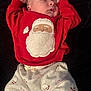 baby, child, christmas, cozy, cute, holiday, indoors, infant, newborn, patterned_clothing, peaceful, portrait, red_sweater, resting, santa_claus, sleeping, small_hands, soft_blanket, white_pants, white_socks