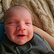 Nico is registered to the contest to win money with this photo: baby, smiling, face, blanket, infant, cozy, clothing, portrait, cute, newborn, warm, soft, child, person, closeup, expression, indoor, happy, head, skin