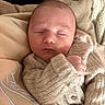 baby, sleeping, infant, knitted_sweater, cozy, pillow, blanket, soft, peaceful, closeup, child, indoors, rest, cute, person, newborn, warm, face, hand, comfort