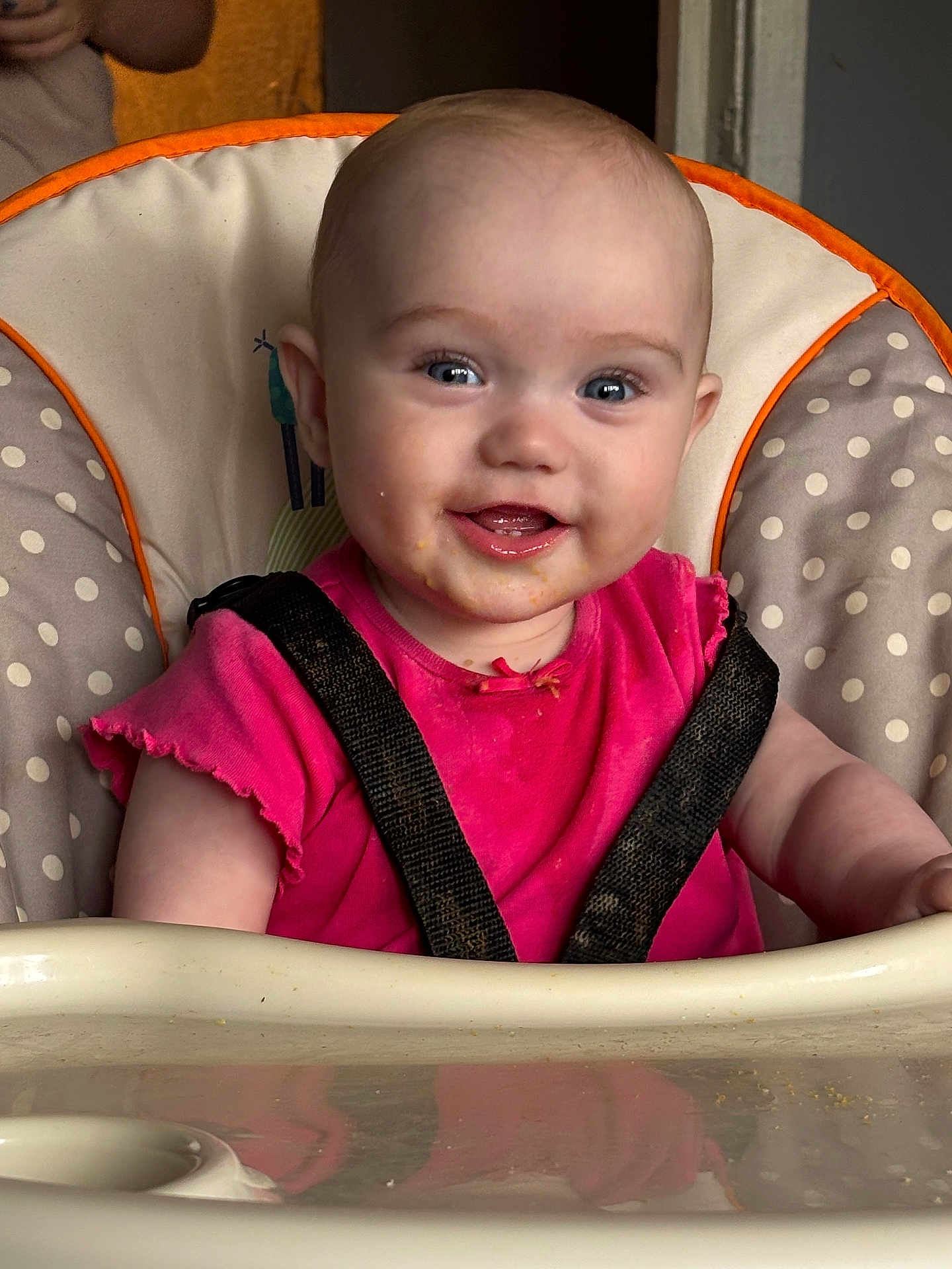 Isabella Witt joined the competition — help win amazing prizes! baby, child, high_chair, pink_shirt, smiling, face, eyes, mouth, seatbelt, polka_dot, cushion, indoor, messy, food, skin, person, portrait, infant, happy, cute