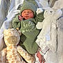 newborn, baby, sleeping, knit_hat, knit_sweater, stuffed_animal, giraffe_toy, bunny_toy, blanket, hospital_bracelet, soft_toys, infant, cozy, cute, child, portrait, indoor, bed, resting, peaceful