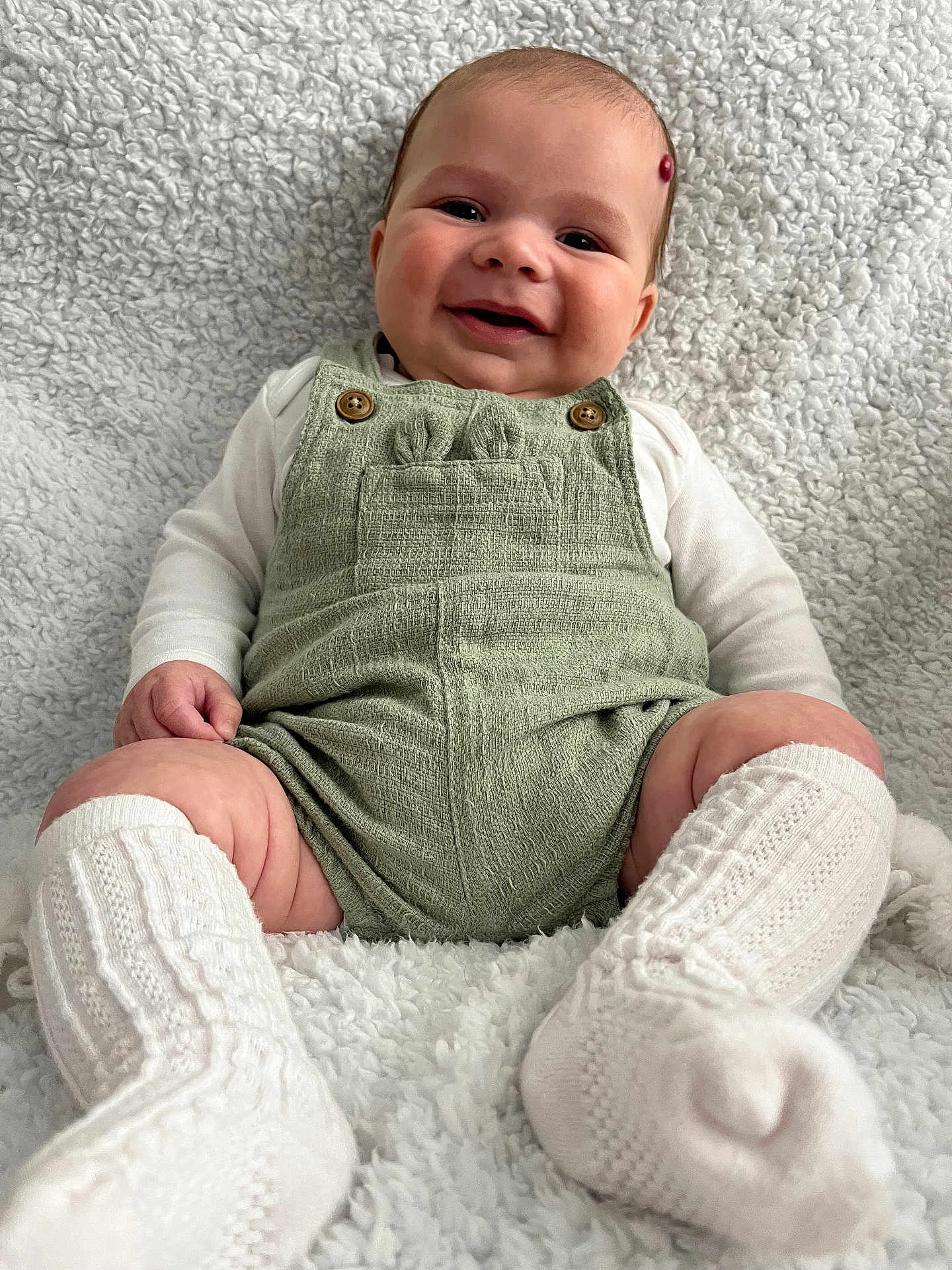 Oakley joined the competition — help win amazing prizes! baby, smiling, romper, white_socks, knitted_socks, blanket, soft_texture, infant, cute, happy, portrait, child, cozy, cuddly, sitting, indoor, warm, comfortable, cute_face, button_details