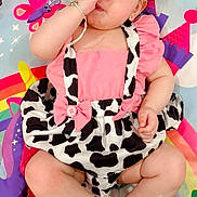 Melissia is registered to the contest to win money with this photo: baby, child, infant, pink_clothing, bow, play_mat, colorful, rainbow, butterfly, sitting, cute, white_shoes, bracelet, face, hand, funny_gesture, patterned_clothing, indoor, happy, young