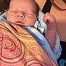 Liam joined the competition — help win amazing prizes! baby, newborn, blanket, patterned_blanket, sleeping, person, arm, indoor, cozy, resting, portrait, infant, child, comfort, soft_light, closeup, skin, head, peaceful, warm