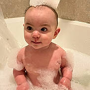 Violet is registered to the contest to win money with this photo: baby, bath, bubbles, foam, child, cute, water, tub, skin, fun, happy, playful, indoors, head, face, sitting, wet, bubble_crown, bathroom, infant