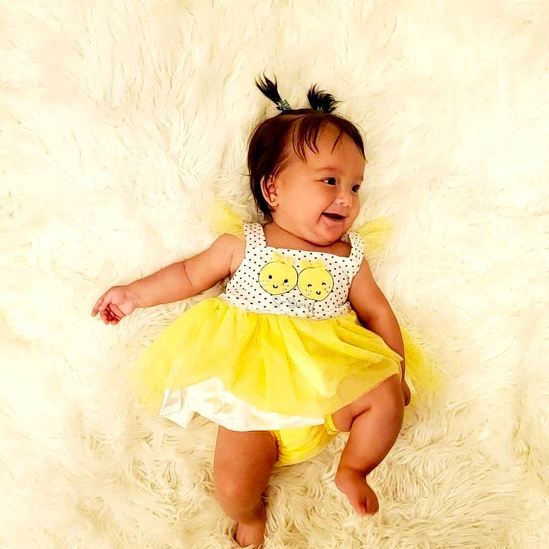 Amaris is registered to the contest to win money with this photo: baby_toddler_clothing, day_dress, dress, eye, face, flash_photography, fun, hair, happy, head, iris, neck, one_piece_garment, pattern, person, skin, sleeve, smile, thigh, toddler