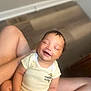 baby, child, smiling, onesie, hello_kitty, yellow_stripes, sitting, indoor, floor, legs, happy, infant, person, cute, skin, head, hand, portrait, relaxed, closed_eyes