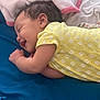 baby, smile, yellow_onesie, blue_bed, blanket, sleeping, infant, child, cute, soft, cozy, portrait, lying_down, happy, indoor, person, fabric, clothing, head, skin