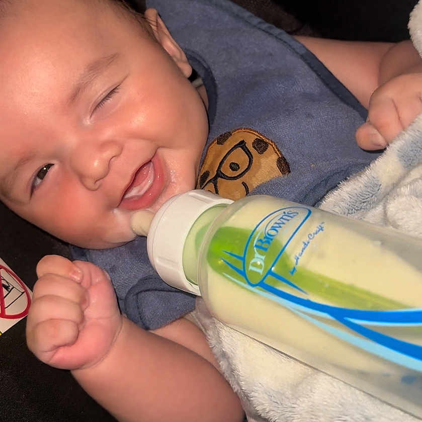 Jayden is registered to the contest to win money with this photo: baby, babylaughing, beverage, bodypart, bottle, couch, face, finger, furniture, hand, happy, head, lotion, milk, newborn, person, photography, portrait, toe, waterbottle