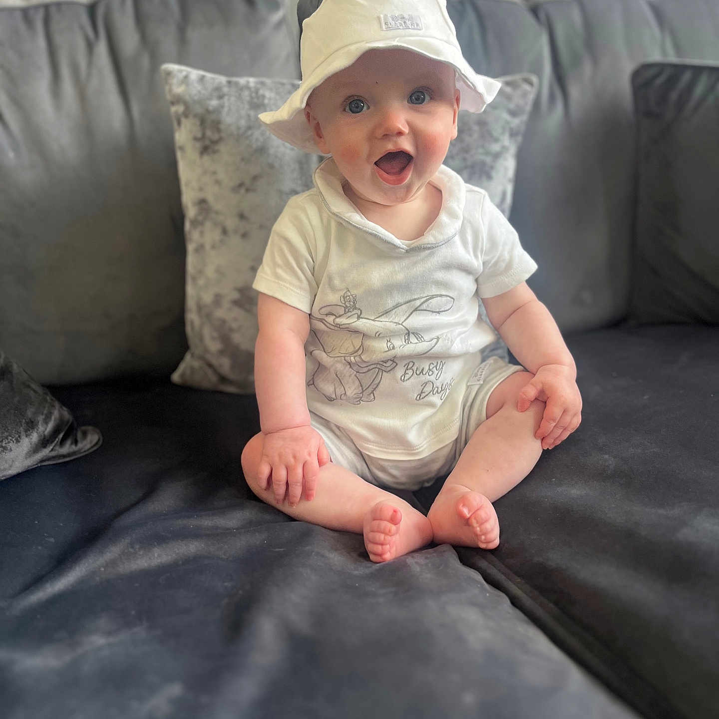 Jaxon is registered to the contest to win money with this photo: architecture, baby, babylaughing, baseballcap, cap, clothing, couch, cushion, face, furniture, happy, hat, head, homedecor, pants, person, photography, portrait, sitting, t_shirt