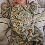 baby, bed, blanket, child, clothing, cozy, cute, face, floral_pattern, hands_up, infant, lying_down, newborn, onesie, pajamas, peaceful, portrait, resting, sleeping, soft