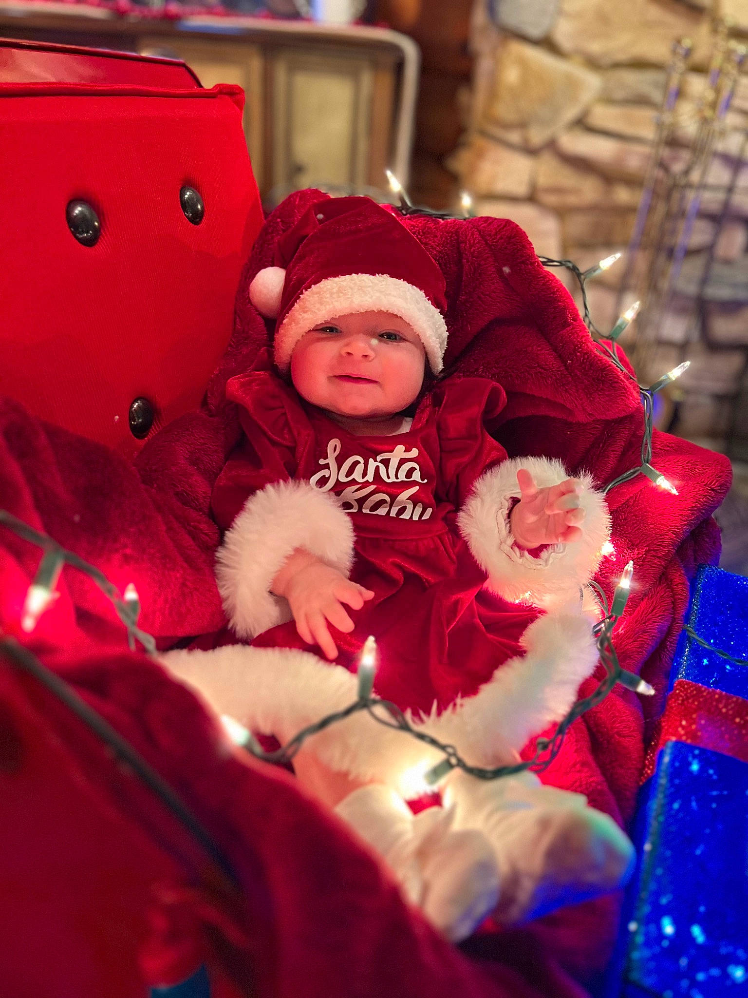 Lylah joined the competition — help win amazing prizes! baby, baby_toddler_clothing, cap, child, christmas, christmas_decoration, comfort, event, fun, happy, headwear, holiday, jacket, lap, magenta, person, plant, sitting, toddler, tradition