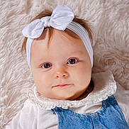 Agathe participe au concours pour gagner de l'argent avec cette photo : baby, child, headband, bow, denim, overalls, white_shirt, frilly_collar, fluffy_blanket, close_up, portrait, cute, infant, face, eyes, skin, hair, lying_down, indoors, soft_texture