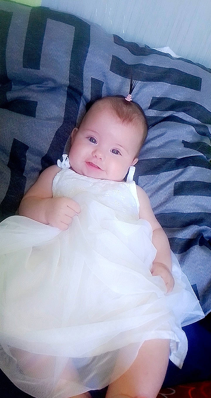 Emma participe au concours pour gagner de l'argent avec cette photo : baby, cheek, child, dress, eye, face, head, iris, person, product, skin, smile, toddler, white